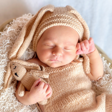 Newborn child sleeping with toy close up