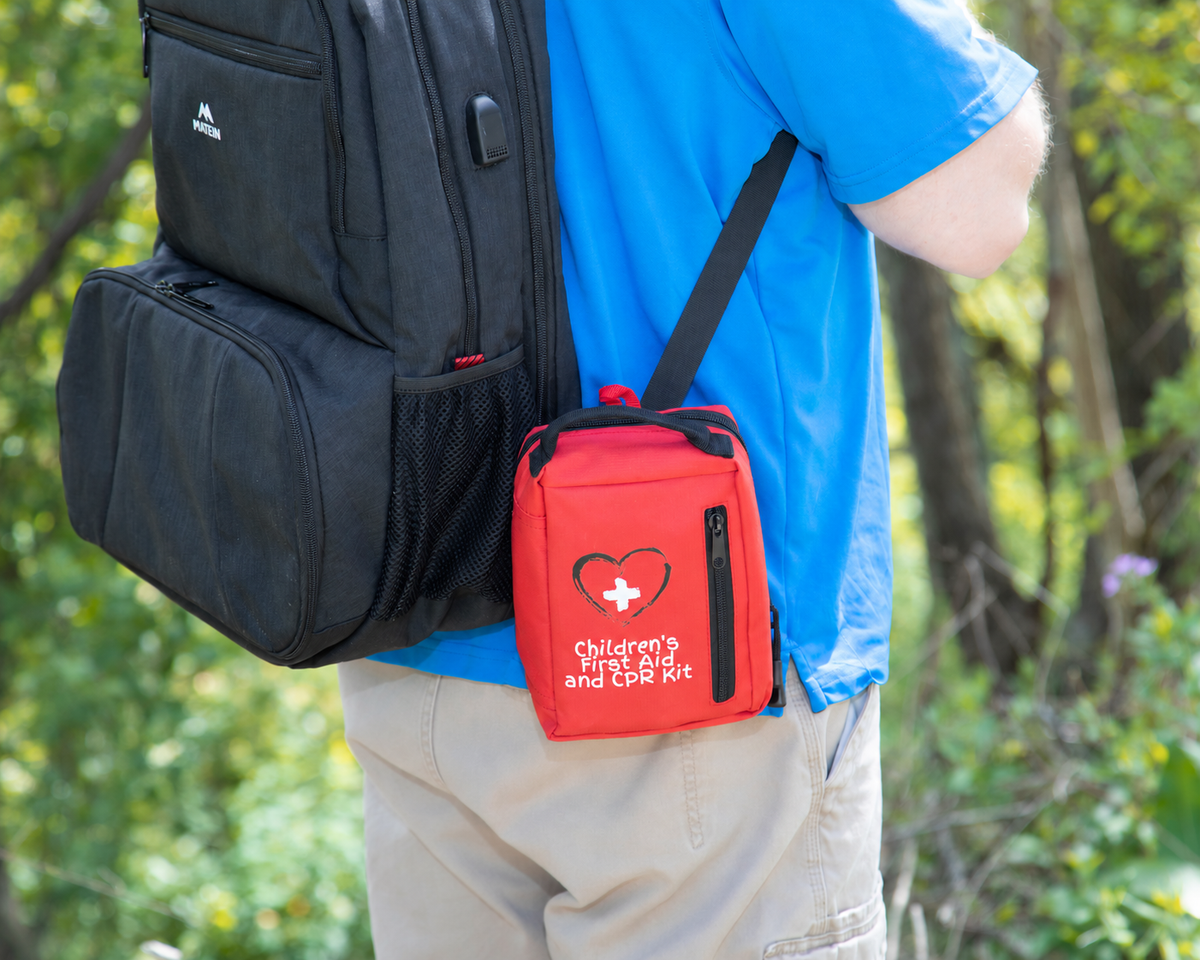 Medium Children’s First Aid and CPR Kit attached to a backpack during an outdoor outing